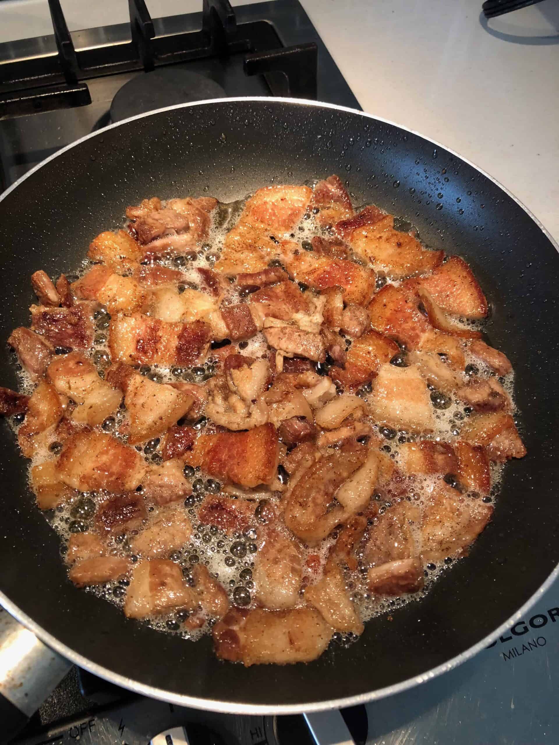 pork belly frying in pan