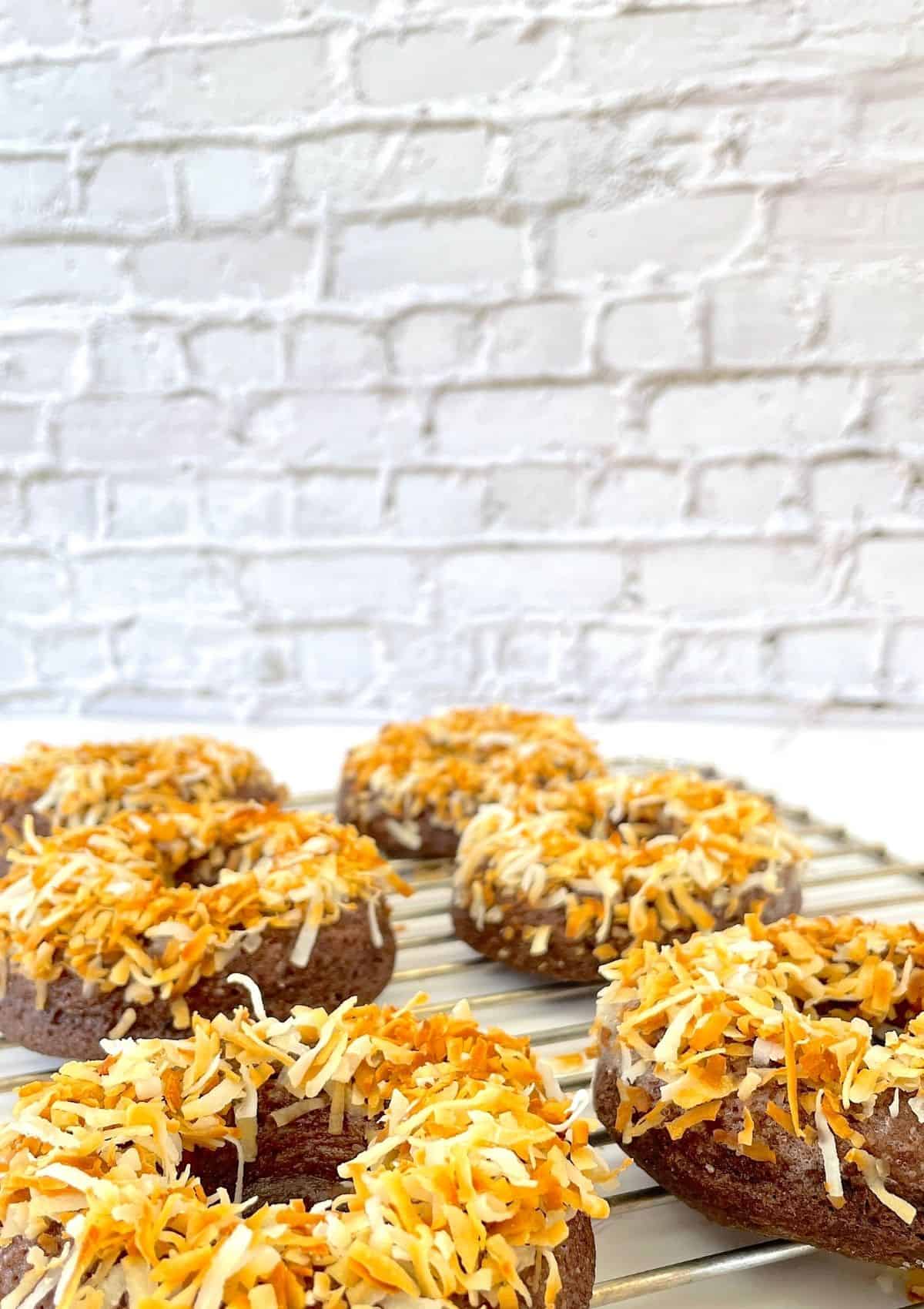 toasted coconut doughnuts on a cooling rack