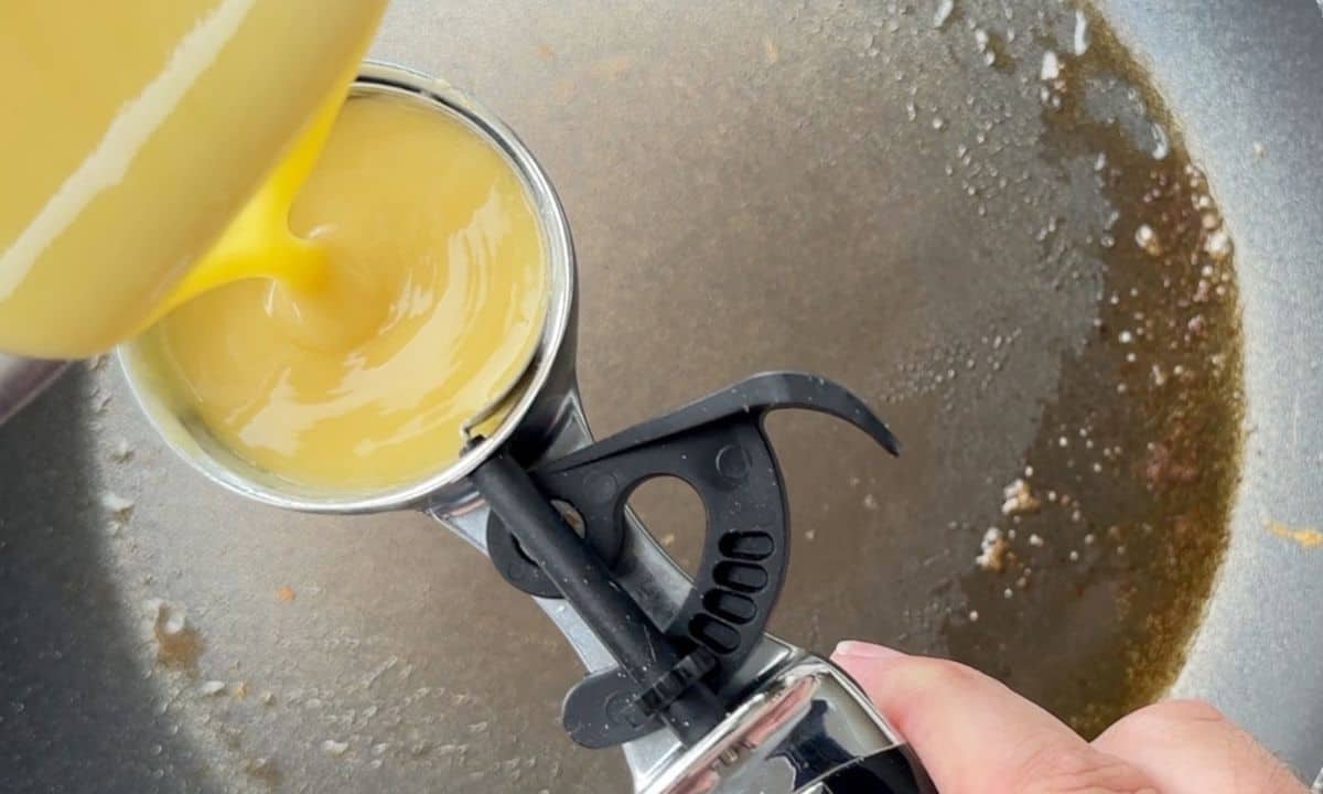 pouring the pancake batter into an ice cream scoop.