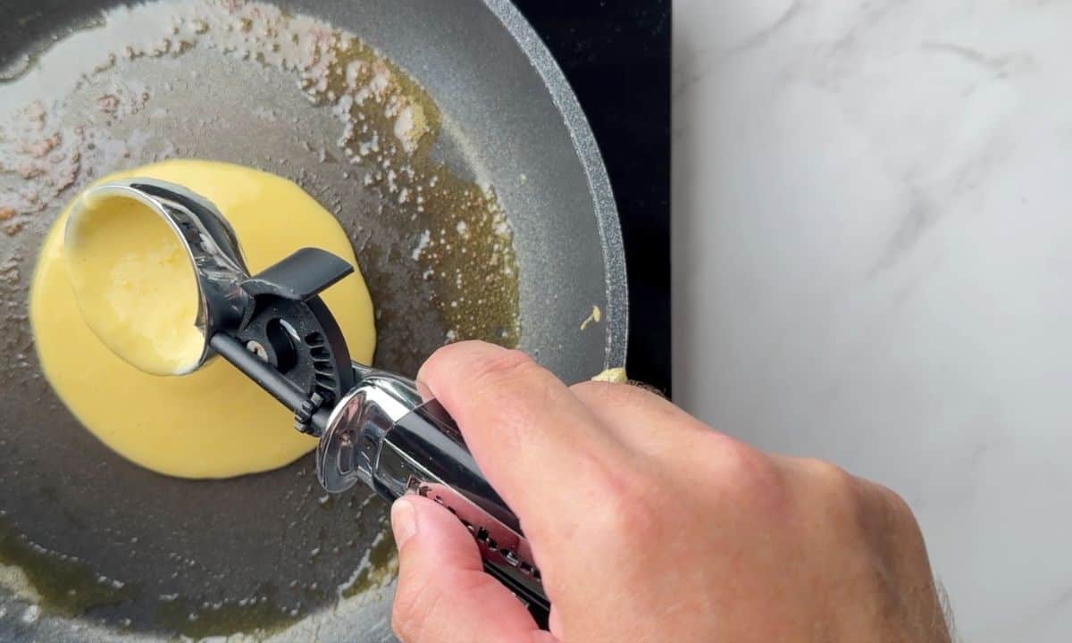 pouring the pancake batter into the frying pan.