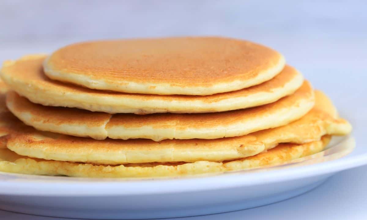 stack of protein powder pancakes on a white plate.