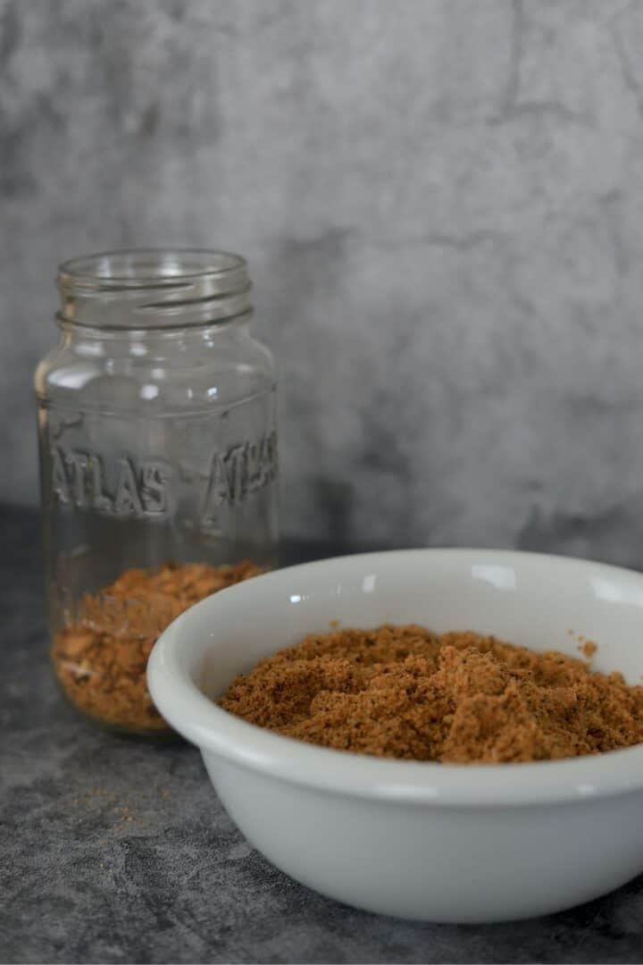breadcrumbs in a bowl next to a mason jar with crumbs