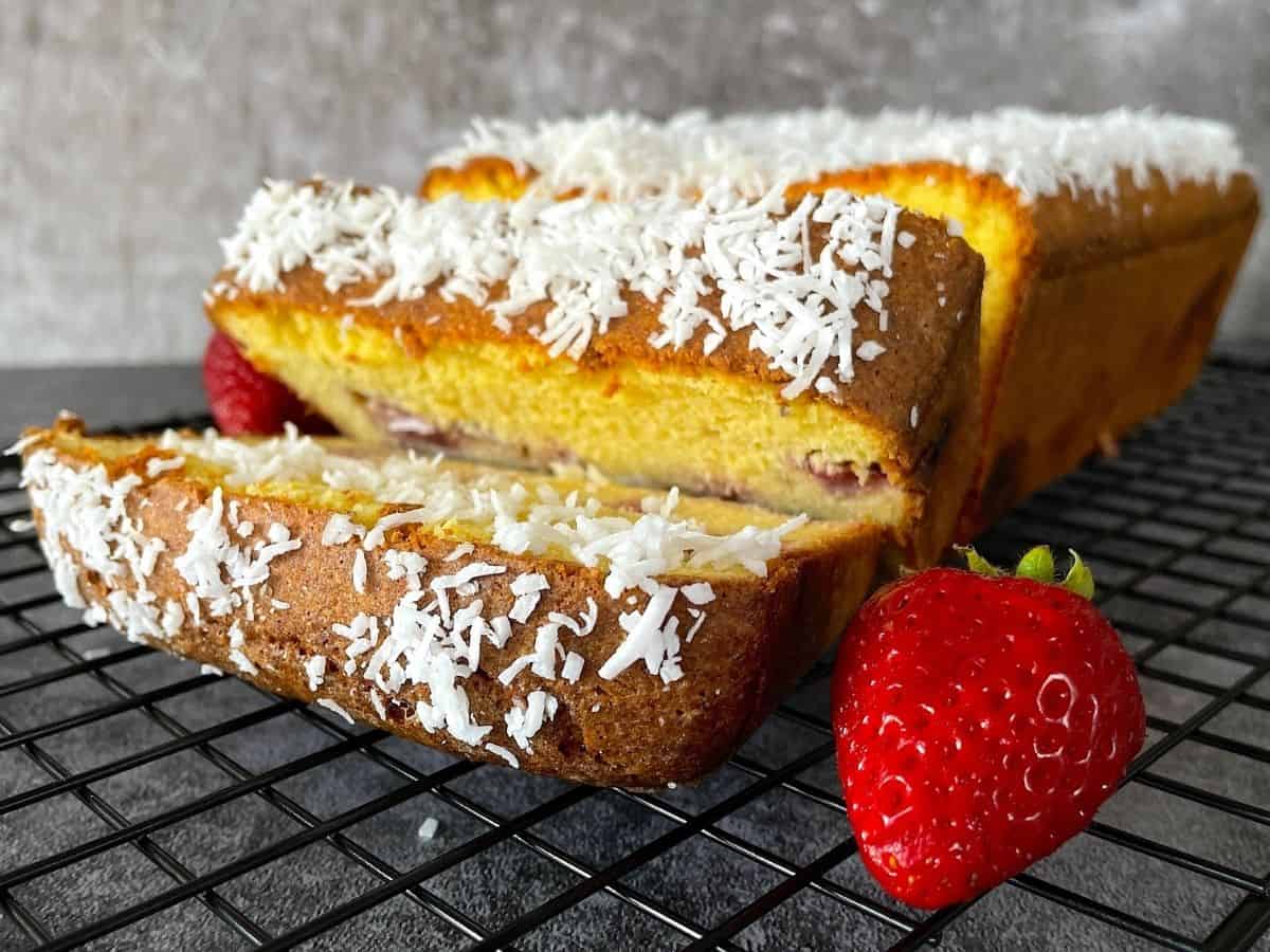 pound cake on cooling rack with fresh strawberries