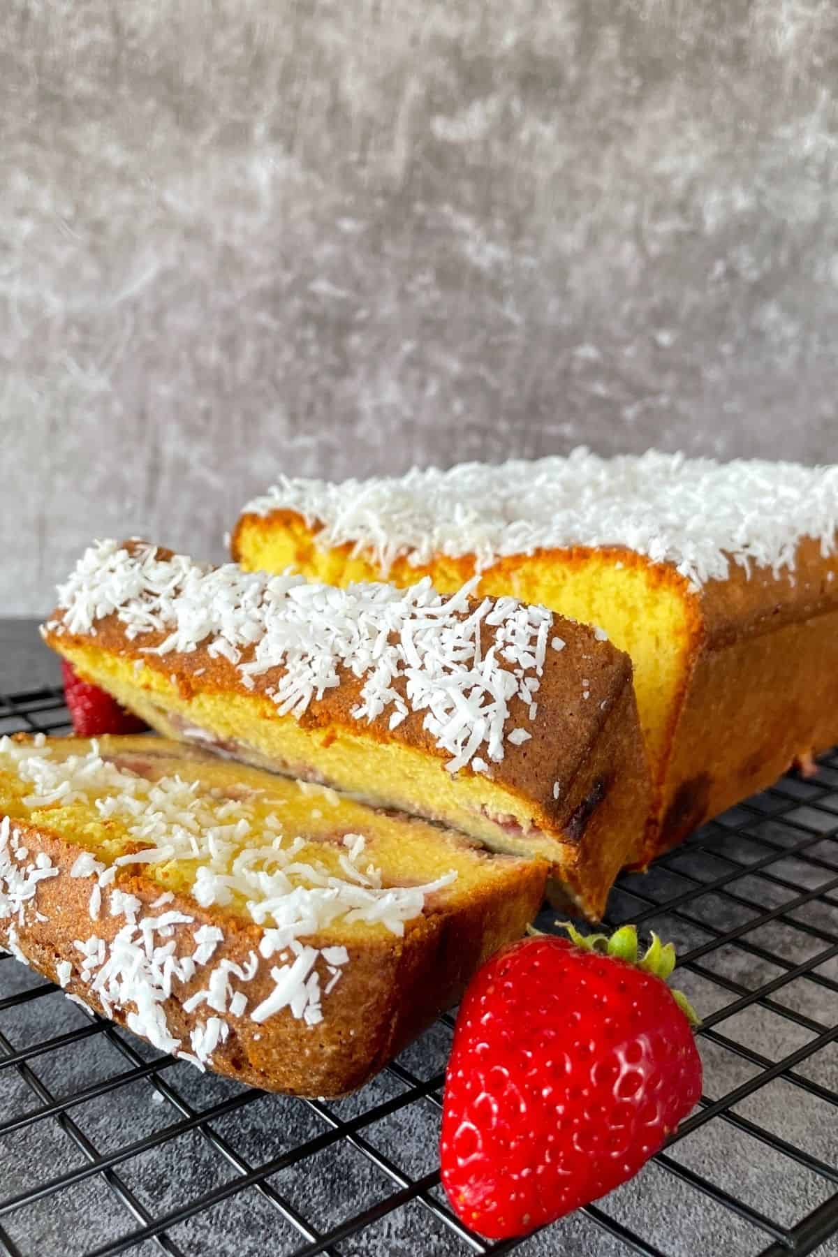 Strawberry pound cake on a cooling rack with fresh strawberries