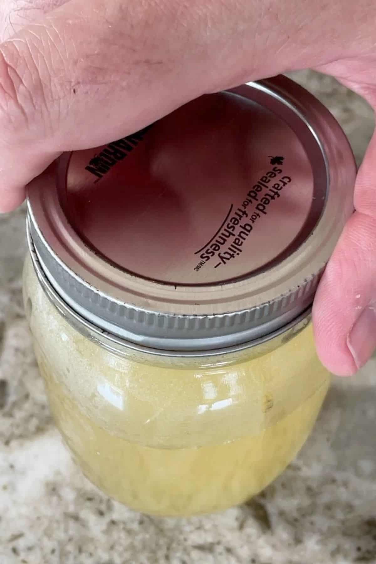 tightening lid on mason jar