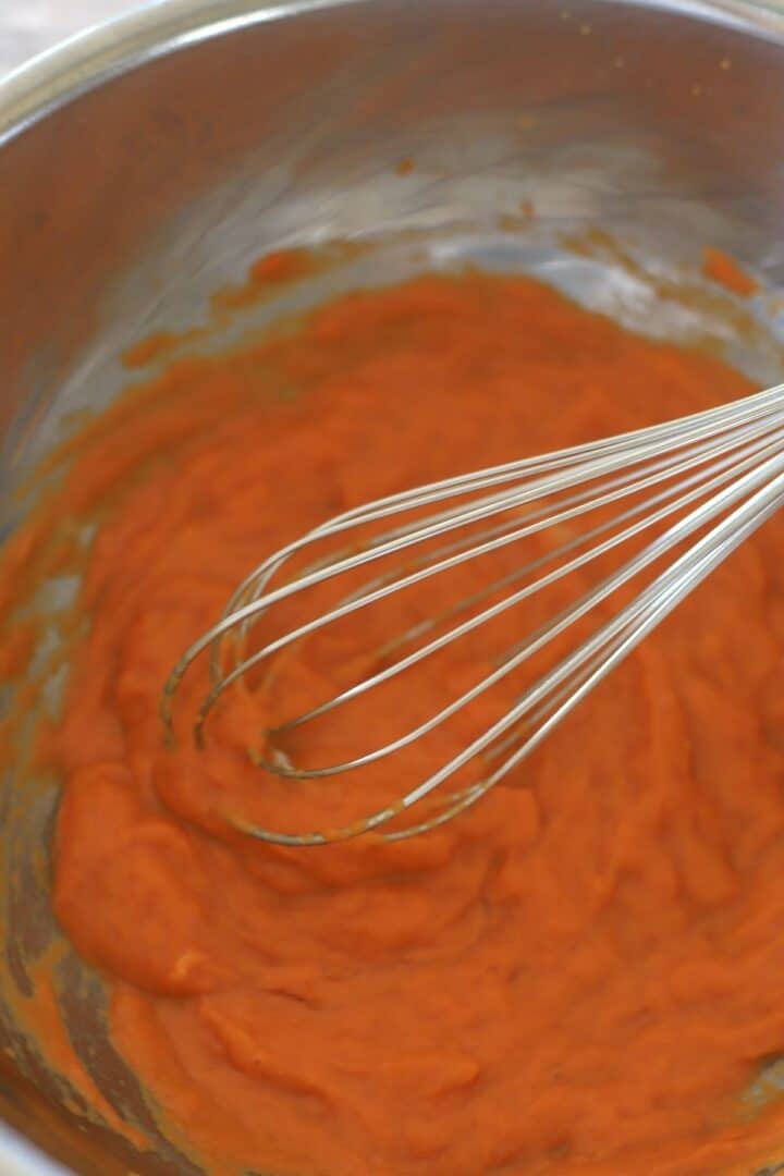 pumpkin puree in a metal bowl with a whisk