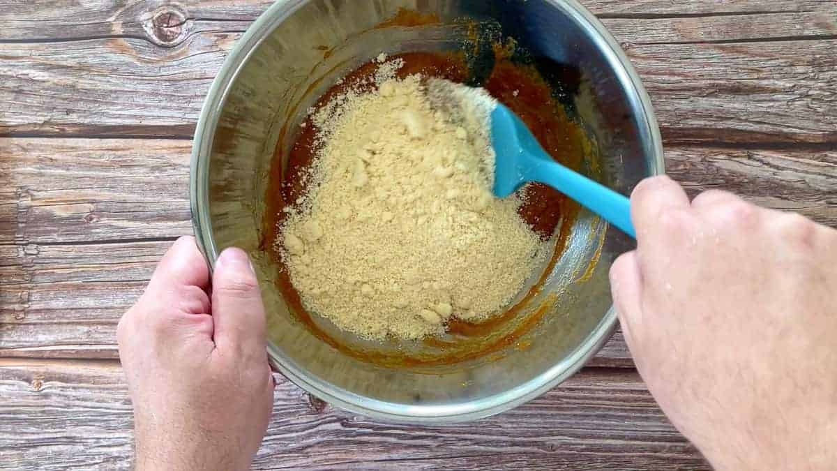 mixing the batter with a blue spatula in a large bowl