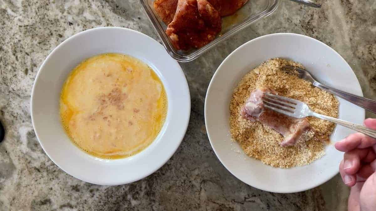 coating the chicken in the breadcrumbs