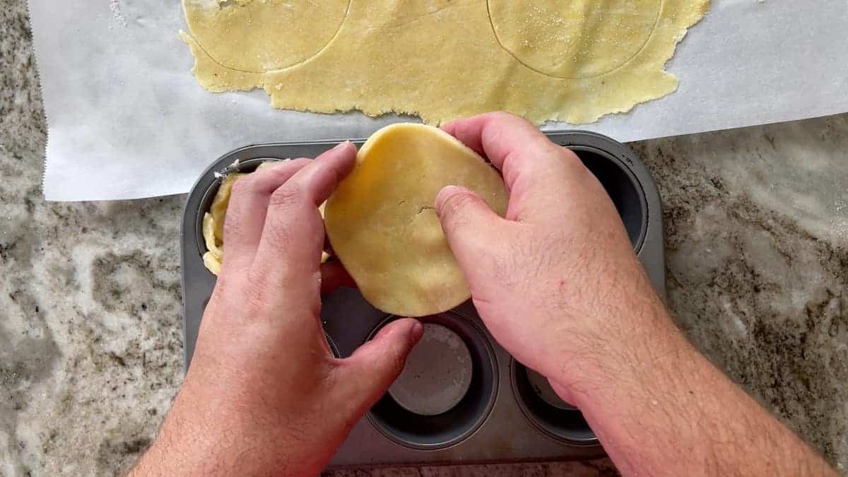 Placing pastry dough shells in the muffin tin