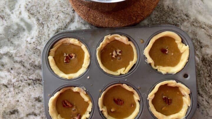 pastry shells with filling and topped with a pecan