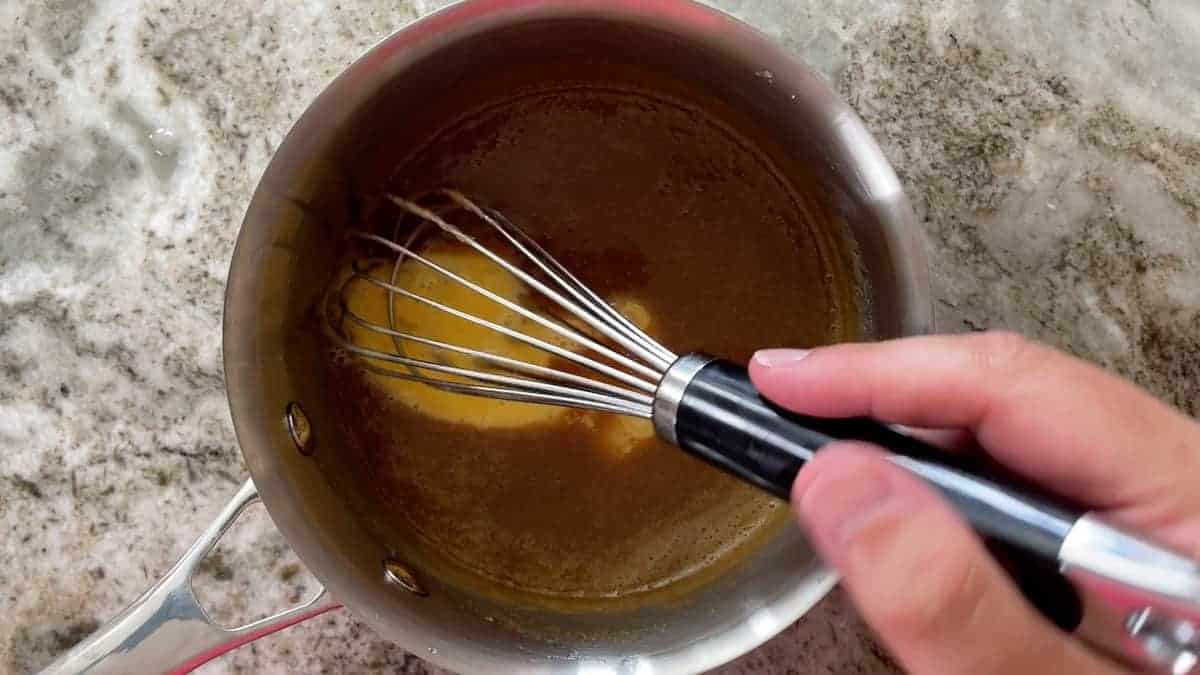 whisking the egg in the saucepan