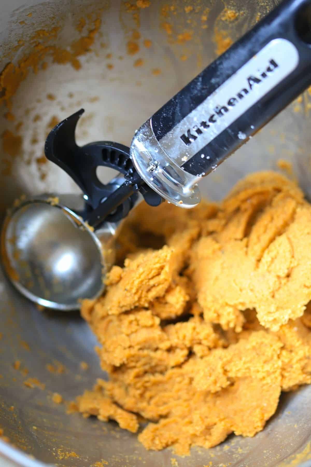 cookie scoop with cookie dough batter in a bowl