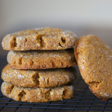 4 pumpkin spice cookies stacked on top of each other with another cookie leaning on the stack