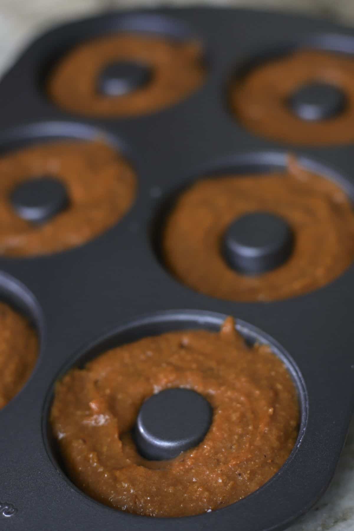 raw donut batter in a donut pan