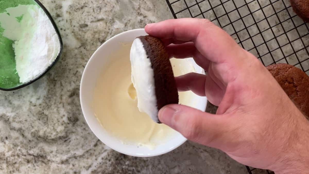 Iced donut above a bowl with icing