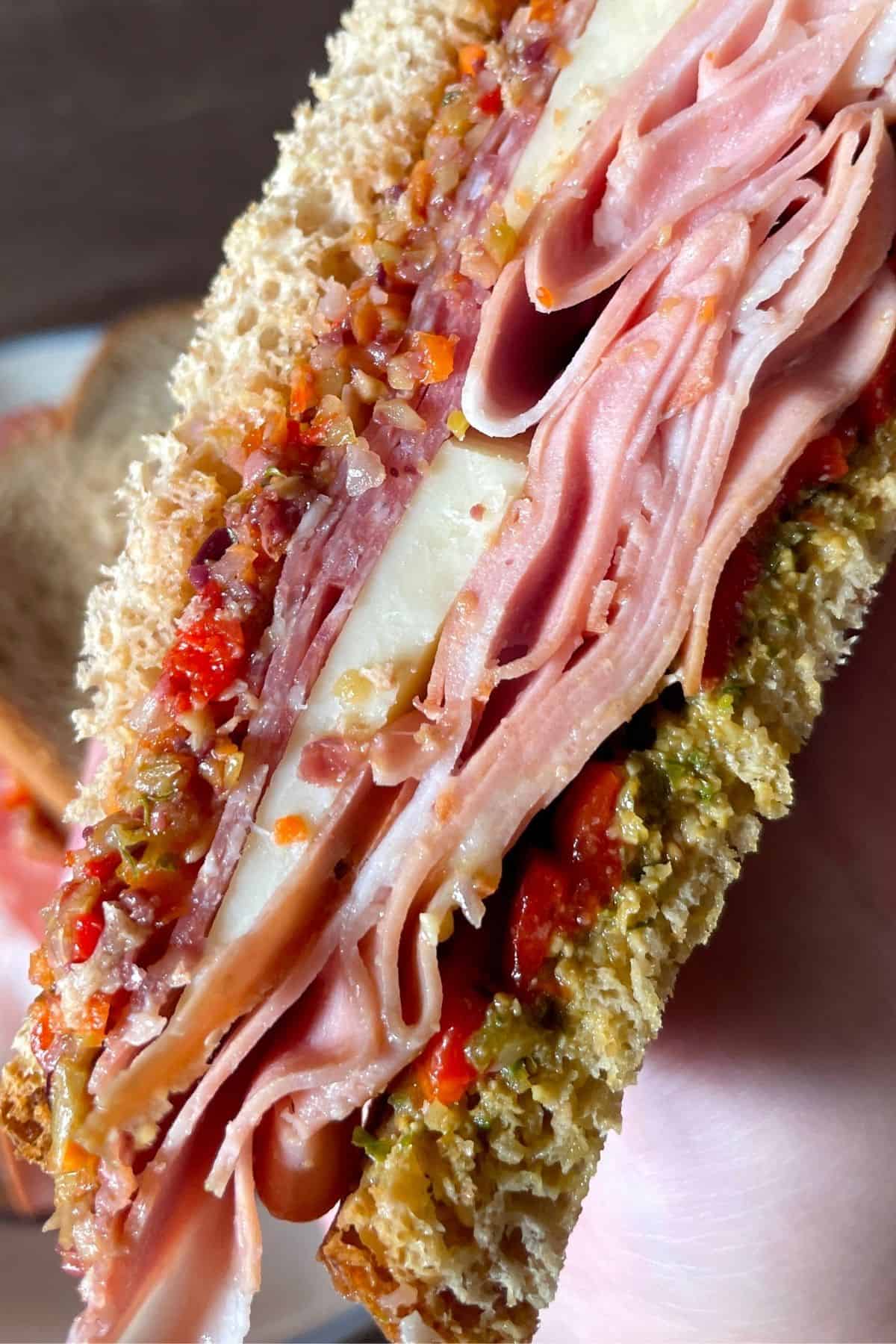 close up of a half deli sandwich with olive spread