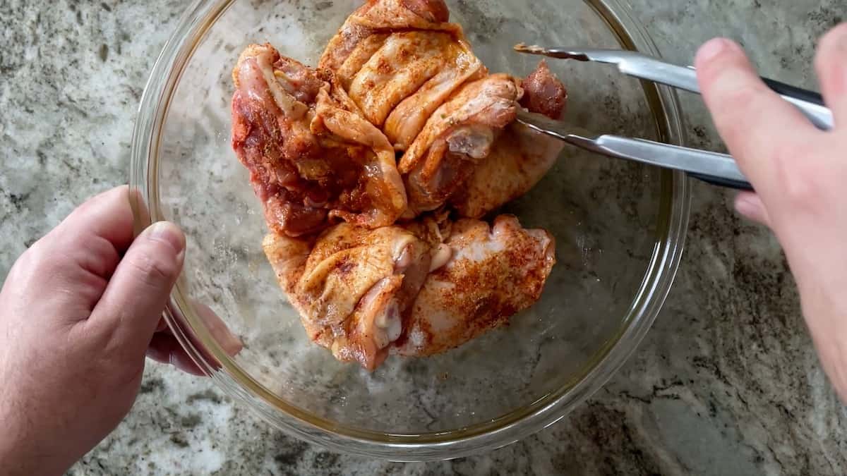 Tossing chicken with spices