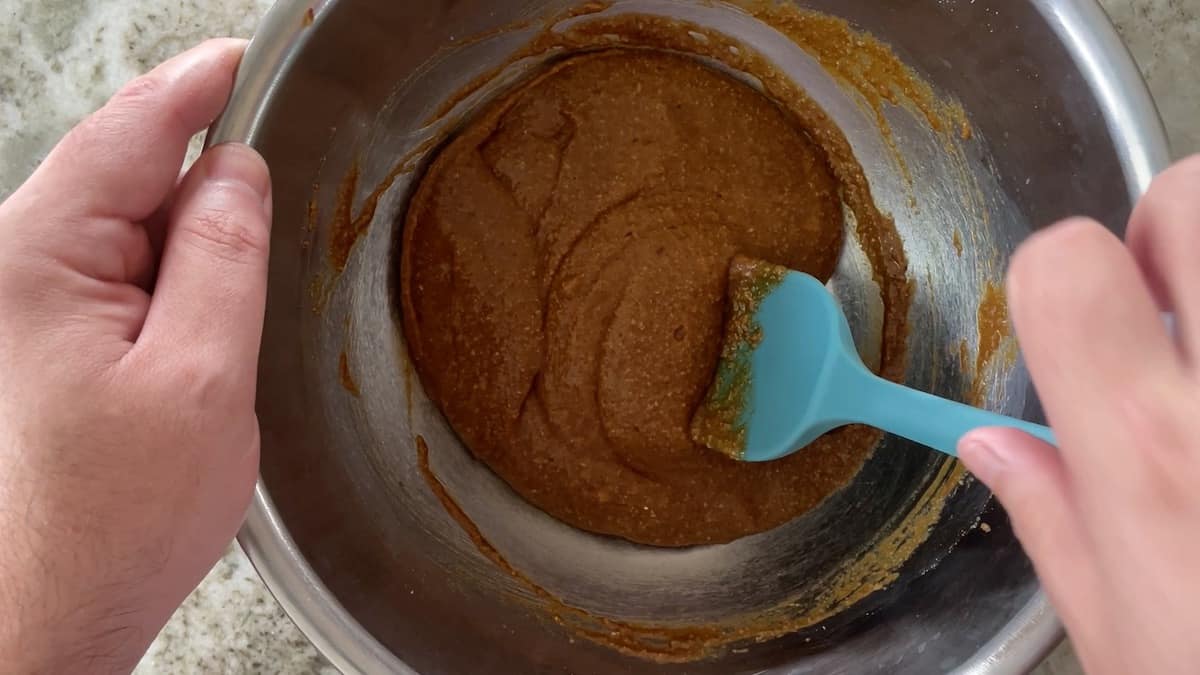 mixing batter in a stainless steel bowl