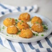 cauliflower balls on a plate garnished with parsley and parmesan