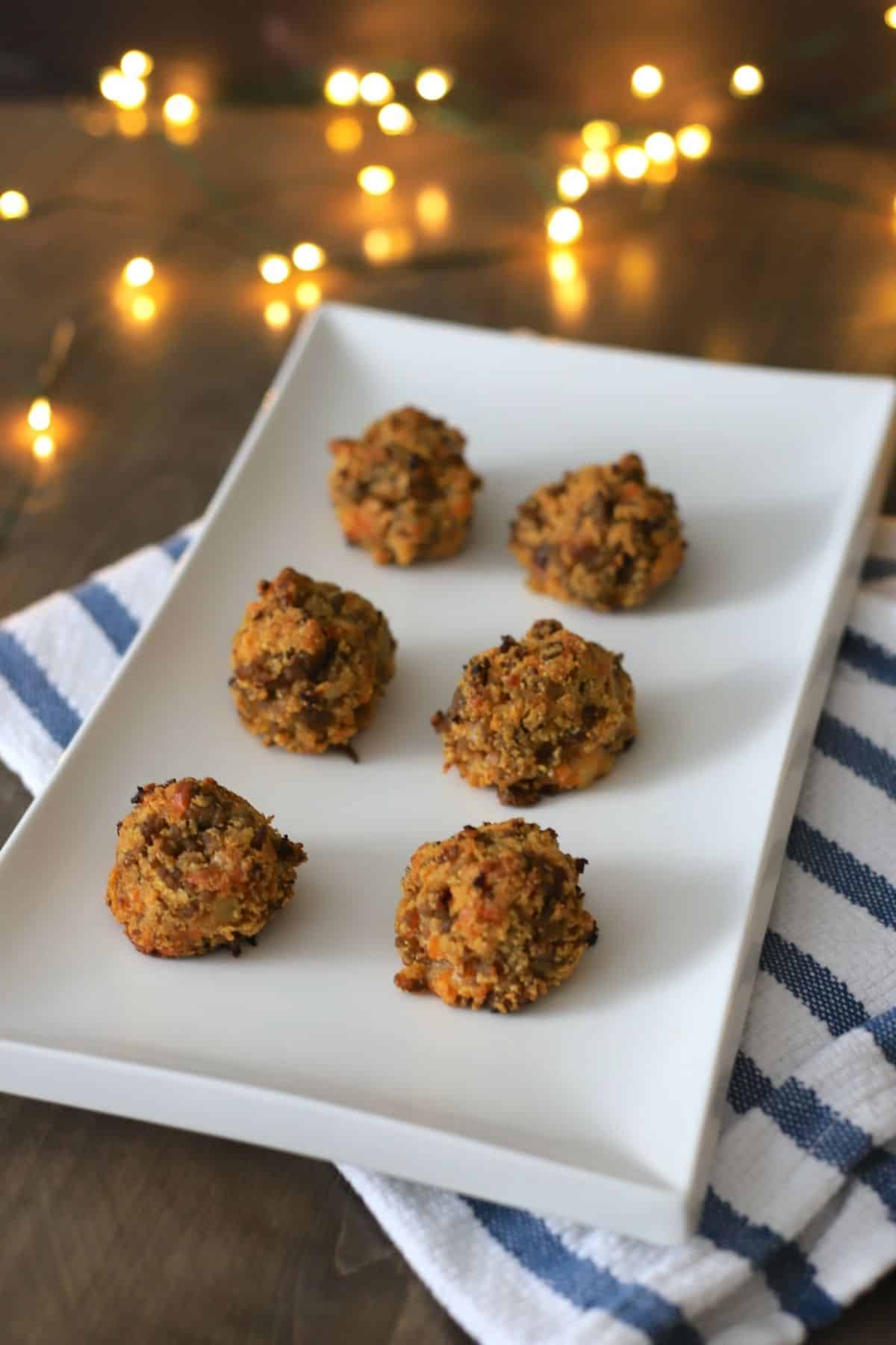 sausage puffs on a white plate with lights in the background