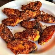 Pork rind crusted chicken wings on a white plate