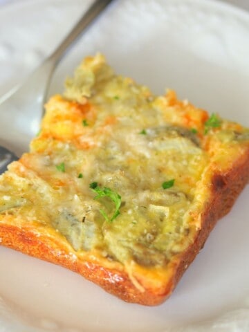 frittata slice on a white plate with a fork