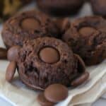 closeup of 3 double chocolate cookies with scattered chocolate chips.