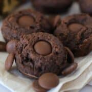 closeup of 3 double chocolate cookies with scattered chocolate chips.