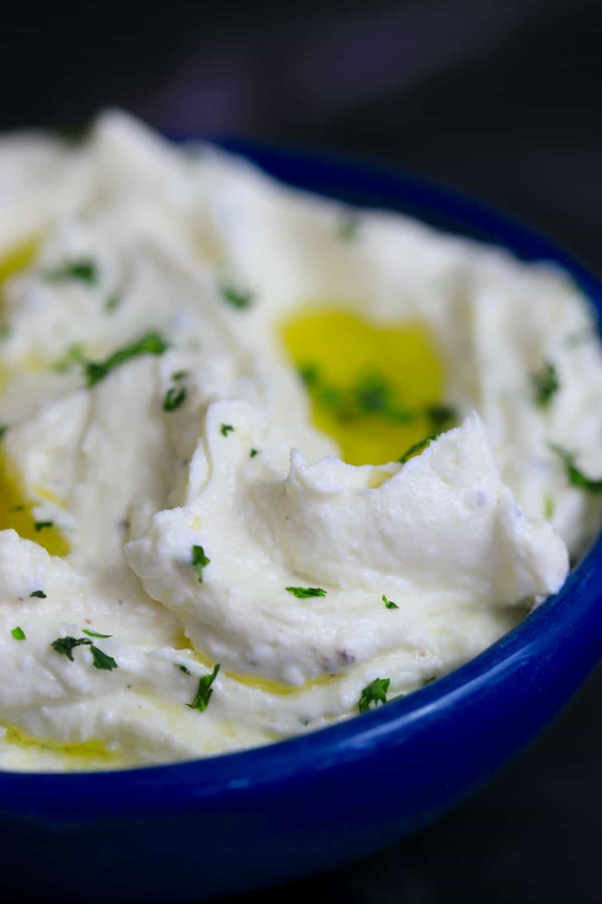 side view of whipped cheese dip in blue bowl