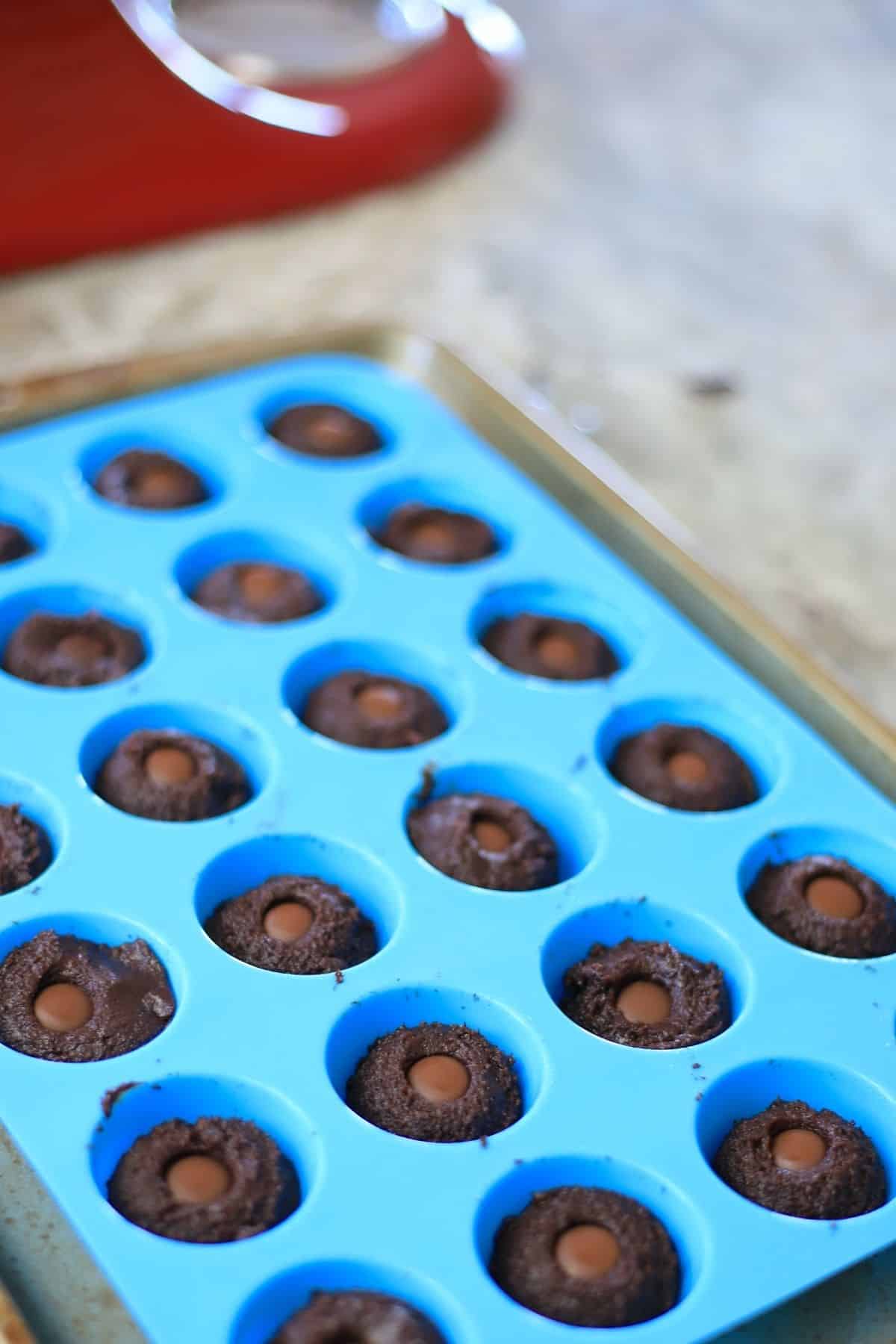 cookies in a blue silicone muffin pan ready for the oven