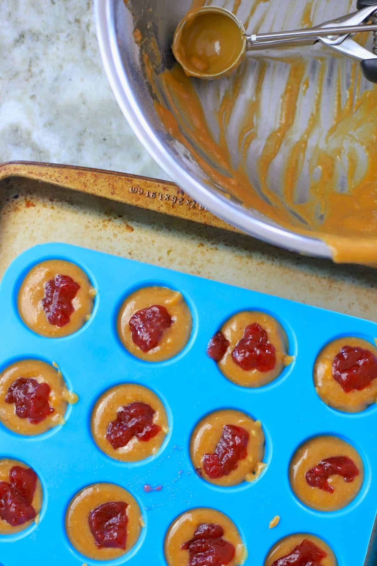 Peanut butter fudge in molds with cookie scoop.