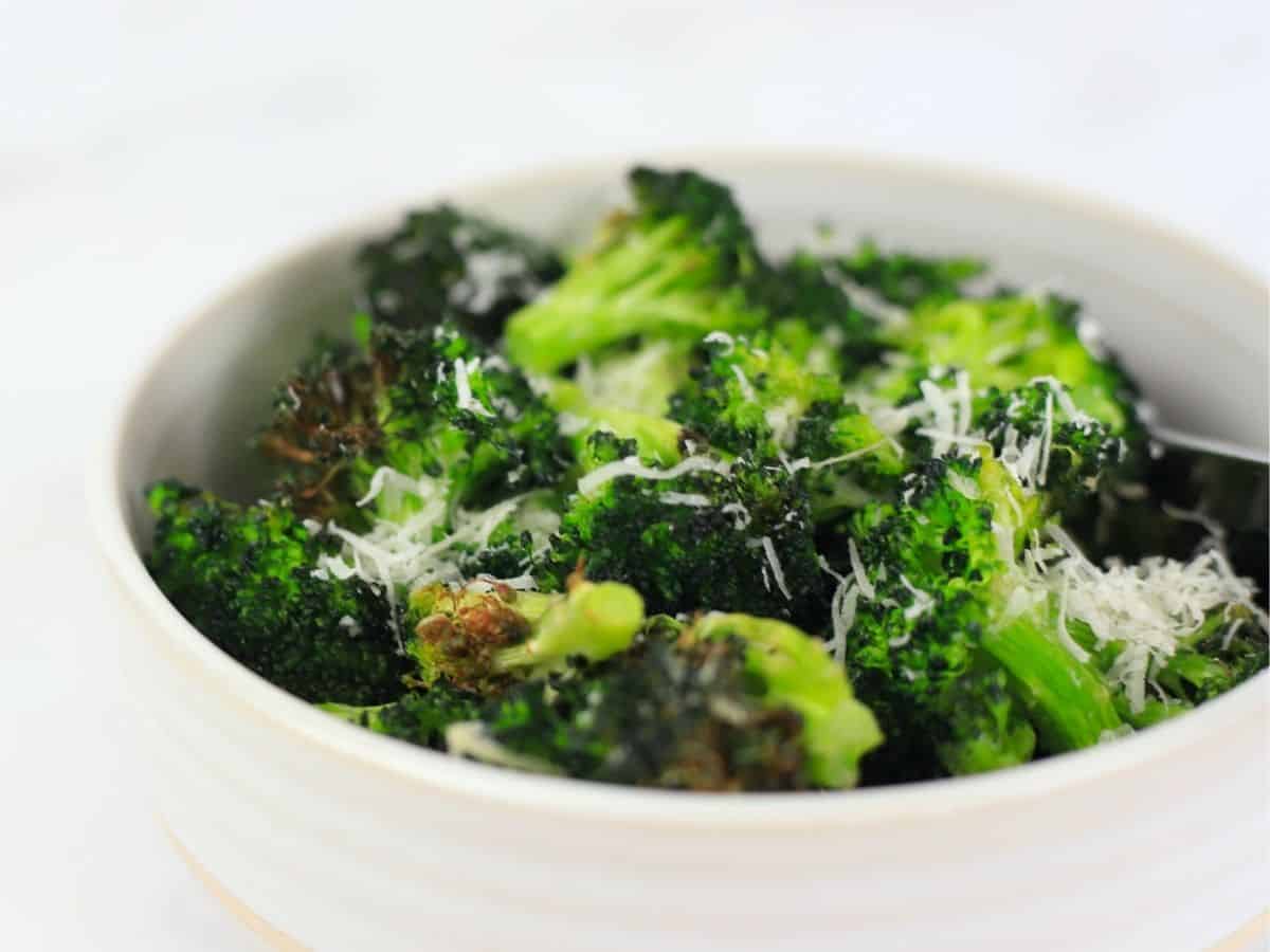 bowl full of the air fryer broccoli sprinkled with parmesan.
