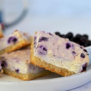 keto cheesecake bars on a plate with blueberries.