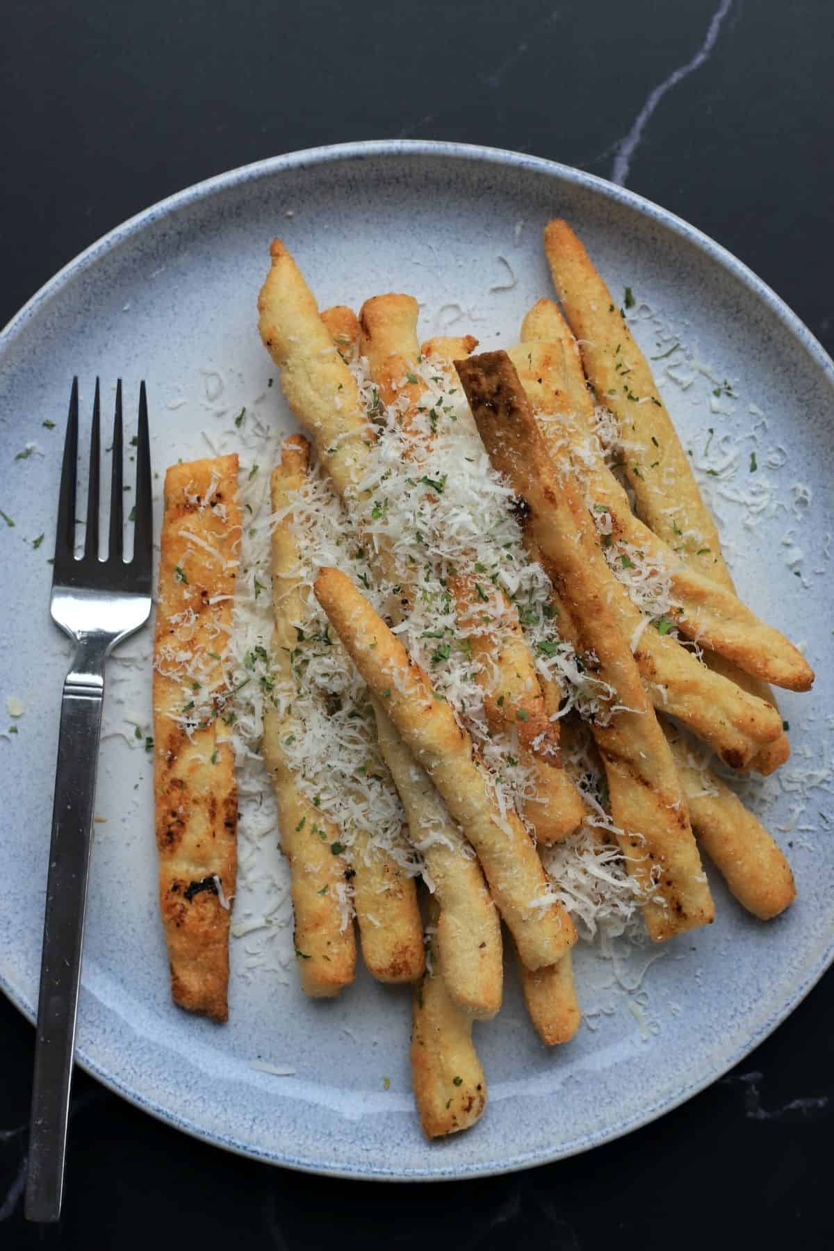 garlic parmesan keto fries on a plate with a fork.