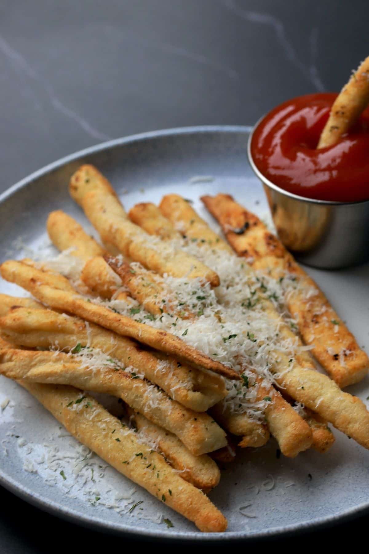 garlic parmesan keto fries on a plate with a side of ketchup.