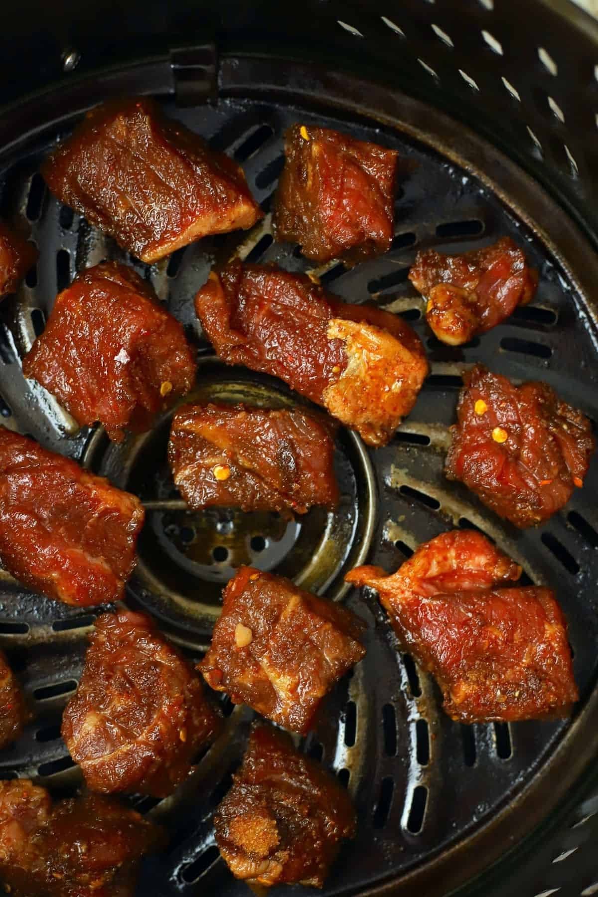 uncooked cubes of keto steak bites in the air fryer basket.