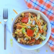 white bowl filled with leftover keto taco salad and a fork.