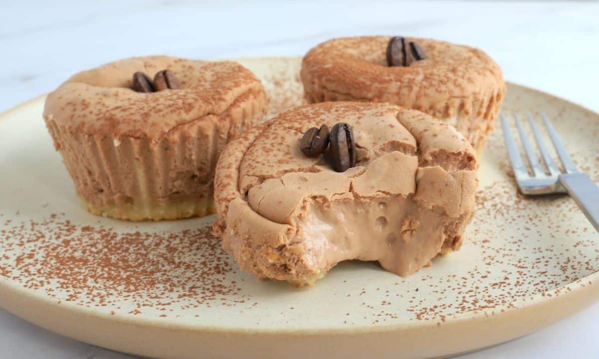 three mini cheesecakes on a plate with a fork.