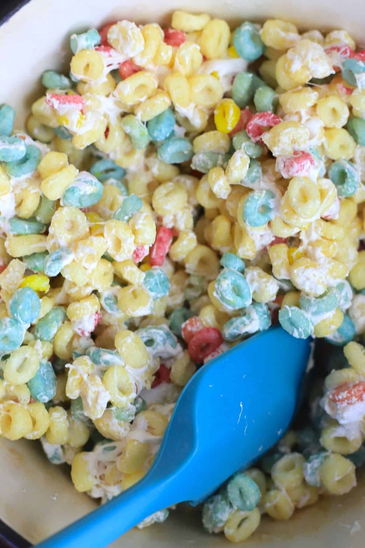 mixing the marshmallow with the fruity cereal.