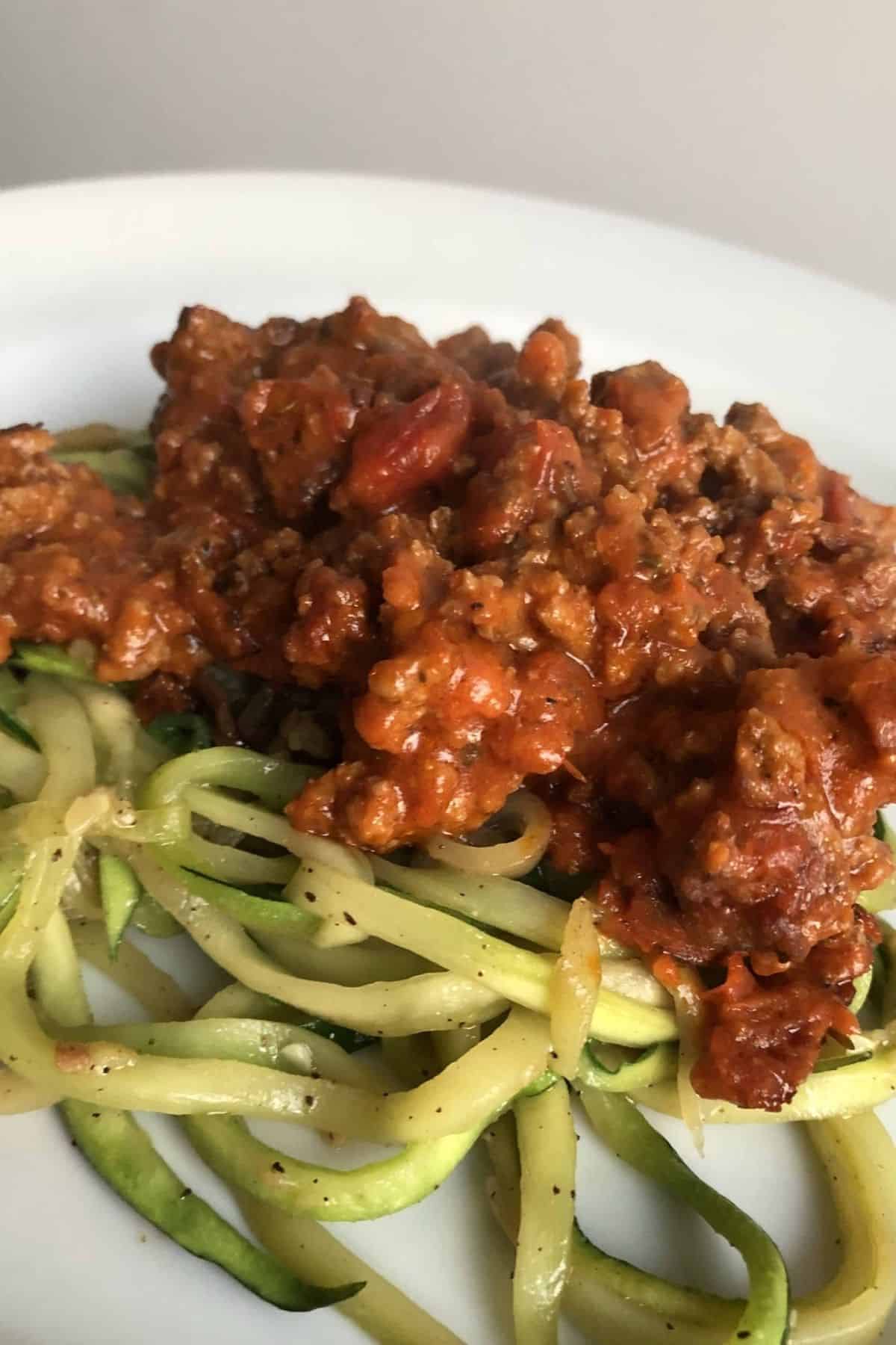 zucchini noodles topped with a meat sauce.
