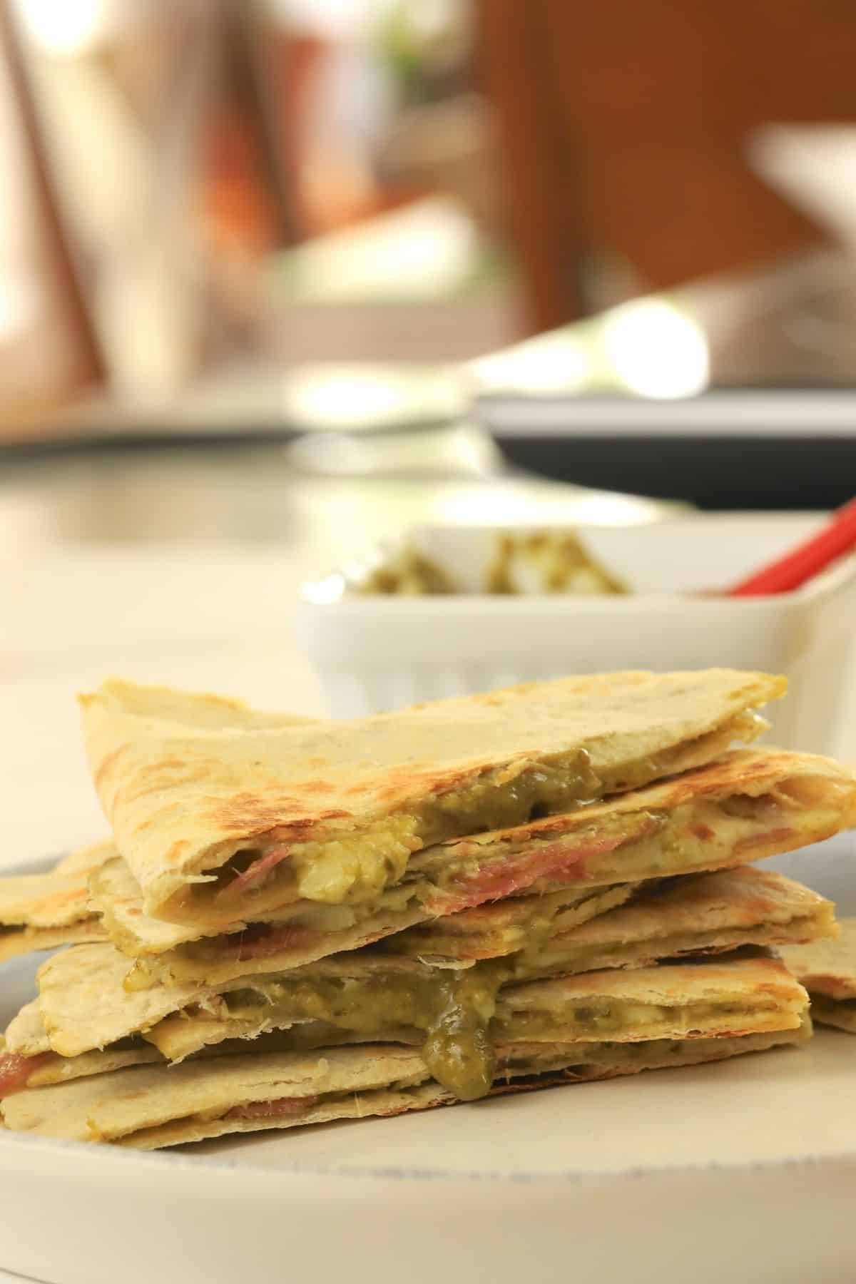 low carb italian quesadillas stacked on top of each other, oozing with pesto and cheese.