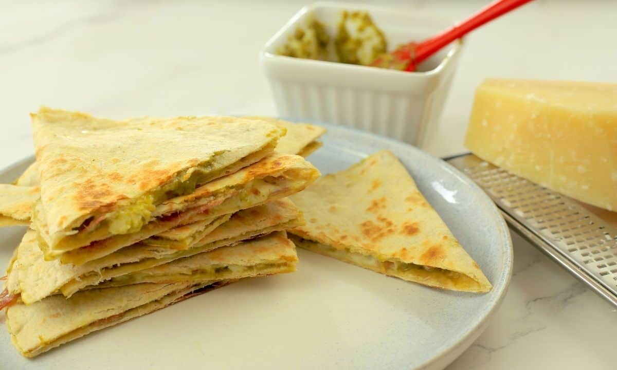 low carb italian quesadillas stacked on top of each other, oozing with pesto and cheese.