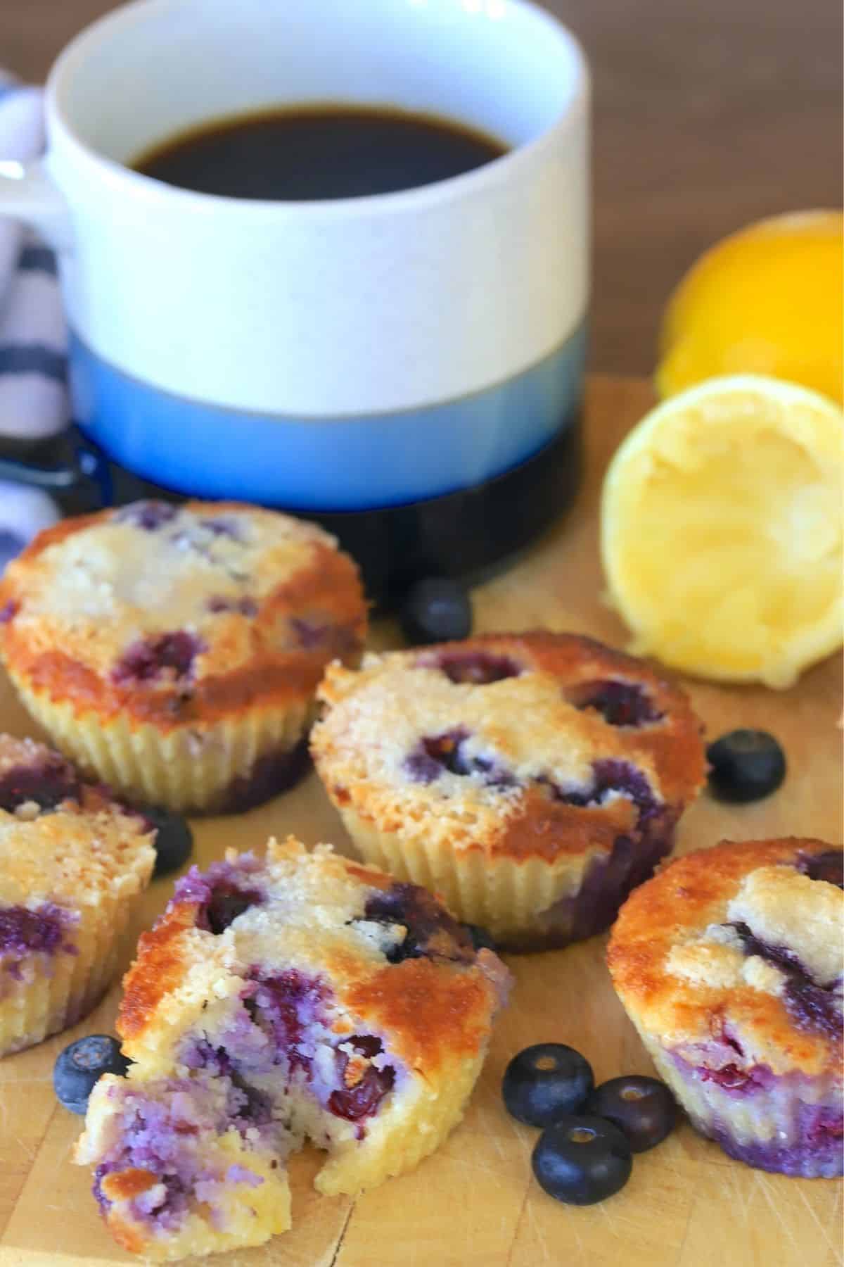 low carb lemon blueberry muffins next to a coffee mug and lemons.