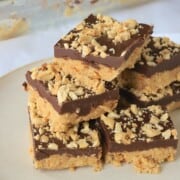 stacked low carb no bake peanut butter bars on a dish.