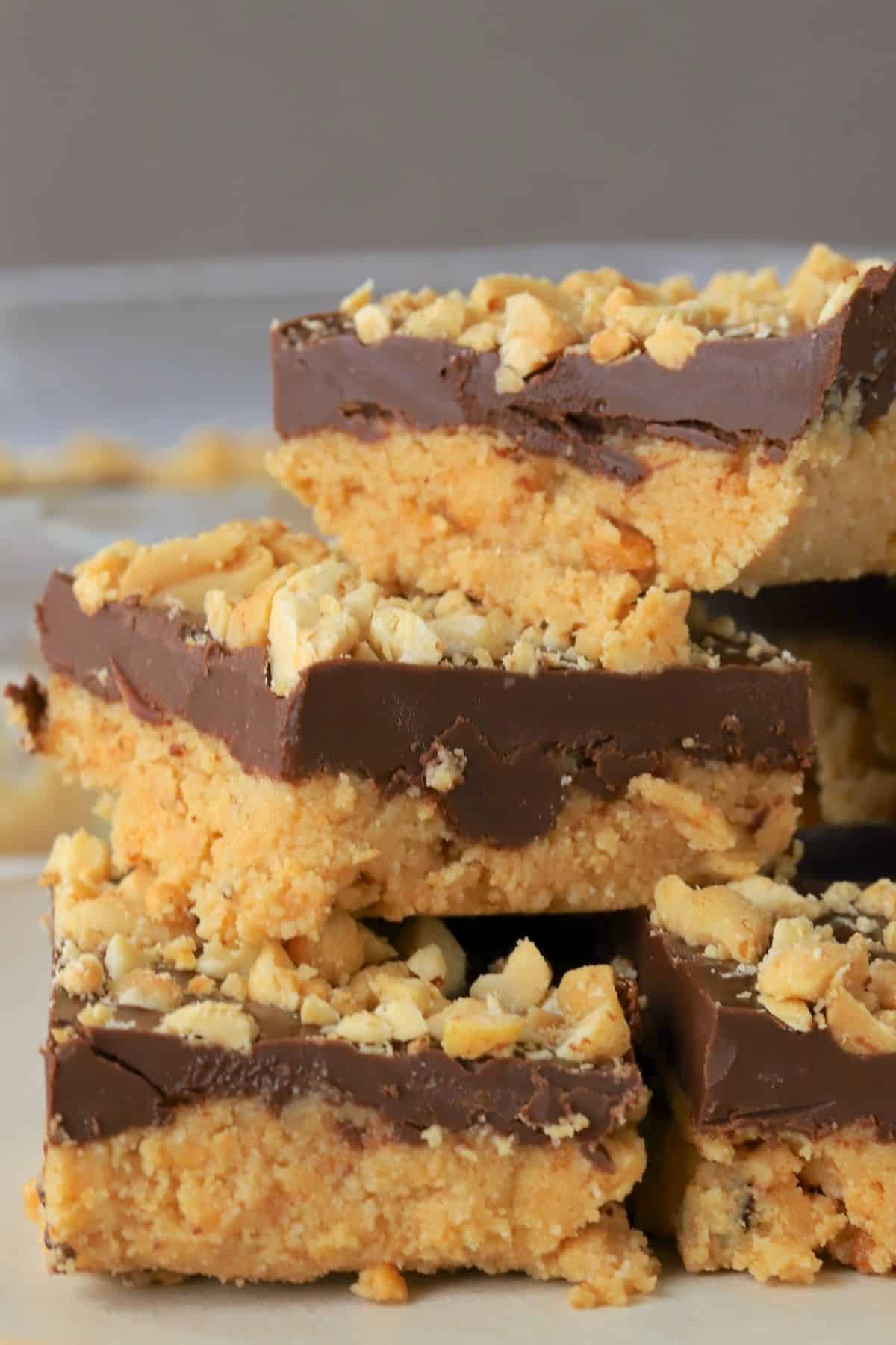stacked low carb no bake peanut butter bars on a plate.