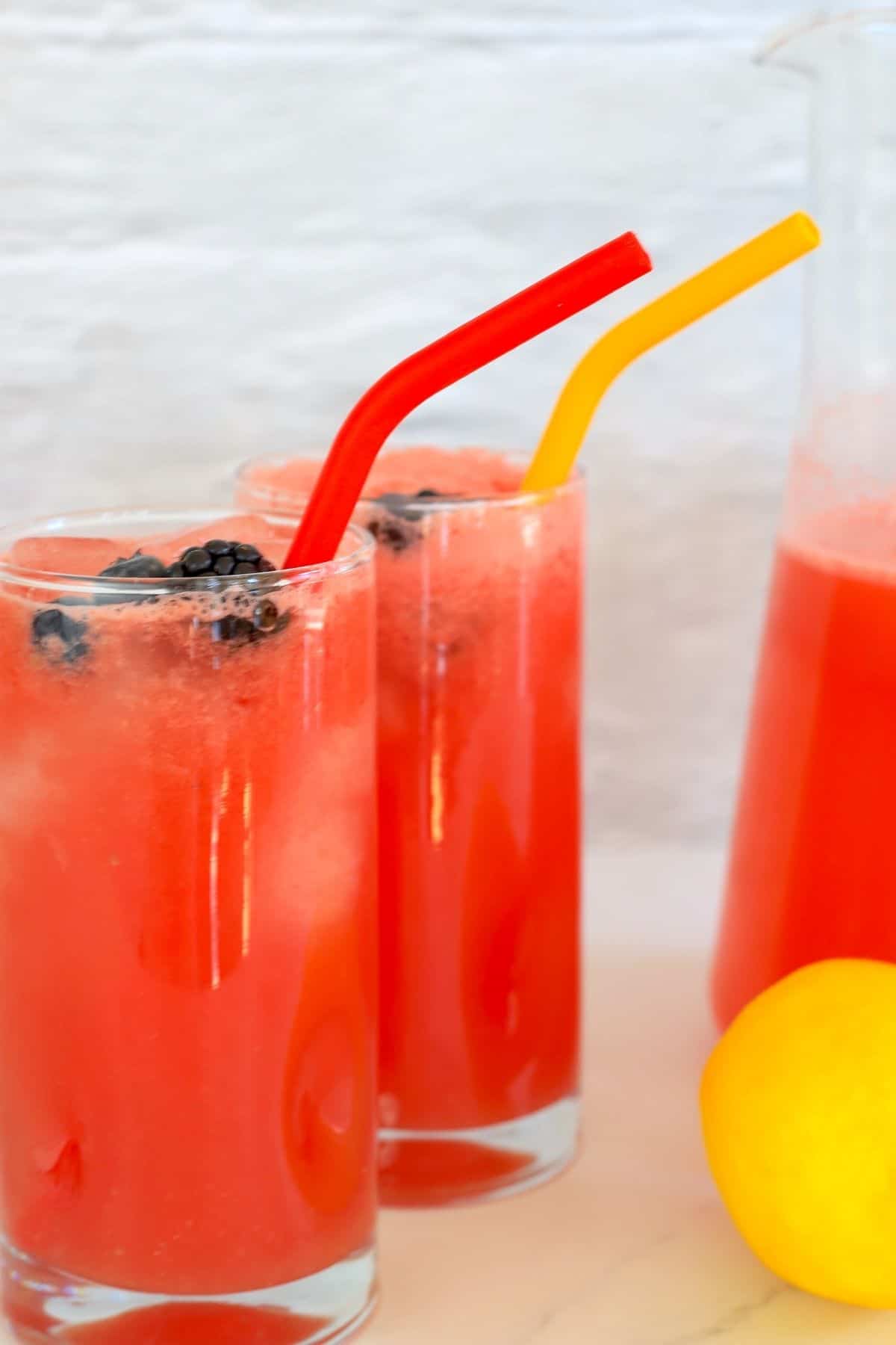 top down view of two highball glasses full with watermelonade and garnished with berries.