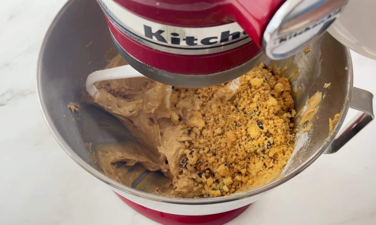 mixing the crumbled cookies with the creamed butters.