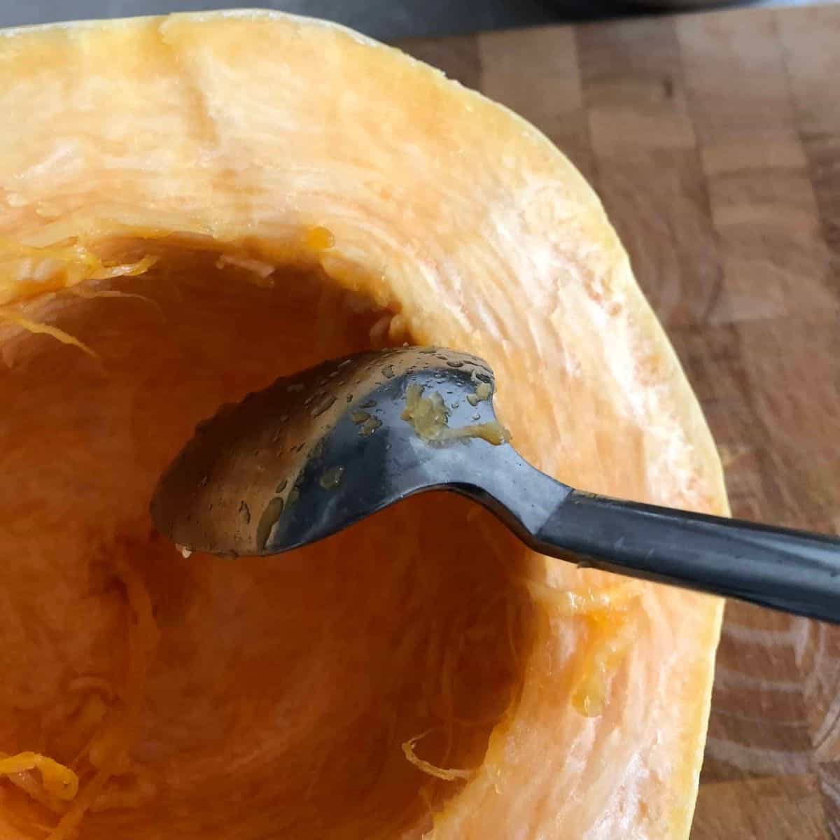 a spoon inside half a spaghetti squash.