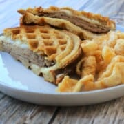 carbonaut waffle sandwich cut in half on a plate with pork rinds.