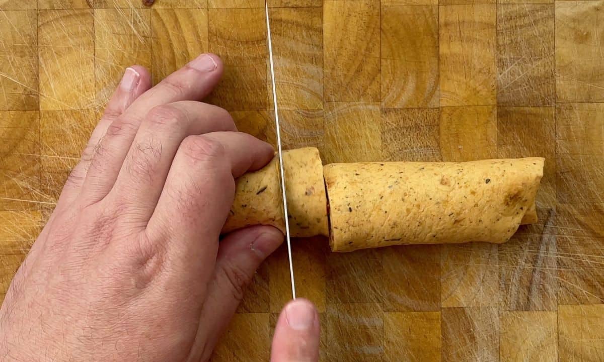slicing the rolled tortilla into pinwheels.
